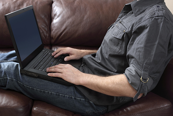 Man using laptop on the couch.