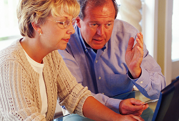 Couple using laptop at home